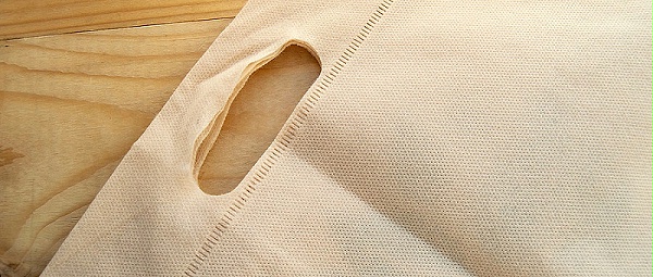 千庫網(wǎng)_放棄塑料袋的概念，無紡布生態(tài)袋，平鋪在淺色木質(zhì)背景上，頂視圖，復(fù)制空間_攝影圖編號14950906